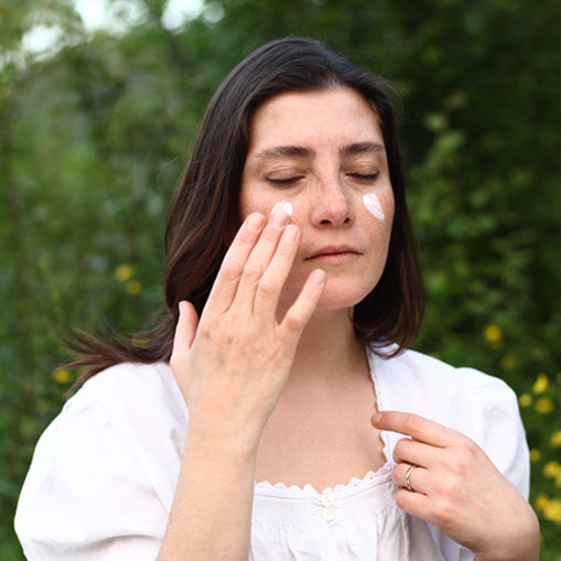 A girl is using ecodrop's organic eczema cream to cure her skin.