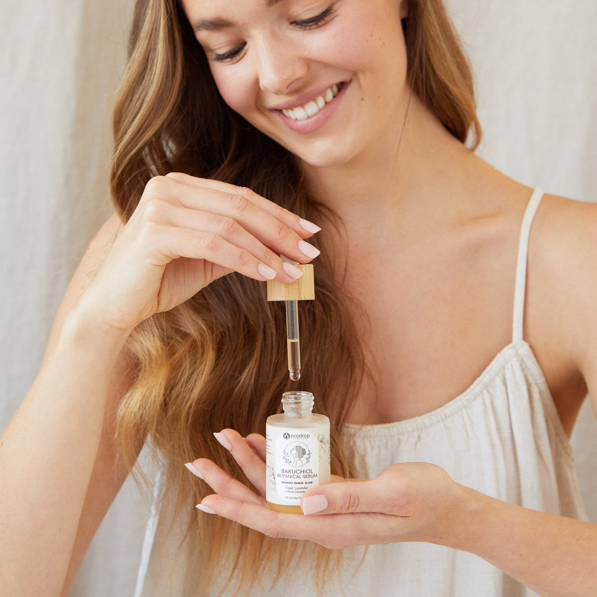Woman applying Ecodrop Bakuchiol Serum face oil with the dropper