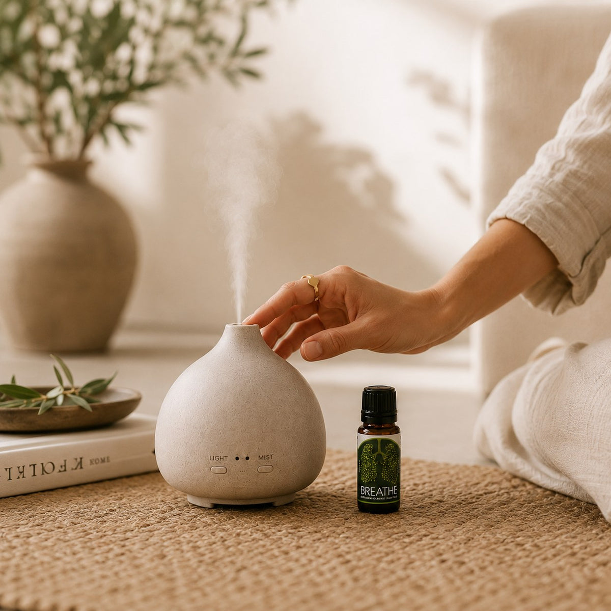 Hand on a ceramic diffuser next to the Breathe Easy blend 10ml