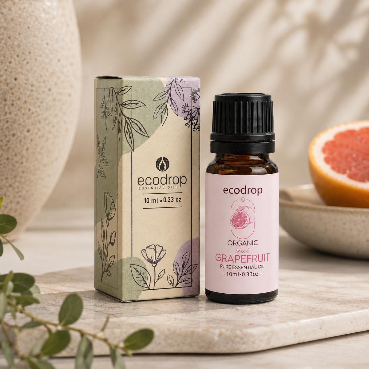 Organic pink grapefruit essential oil 10ml bottle with its recycled carton box and fresh grapefruit