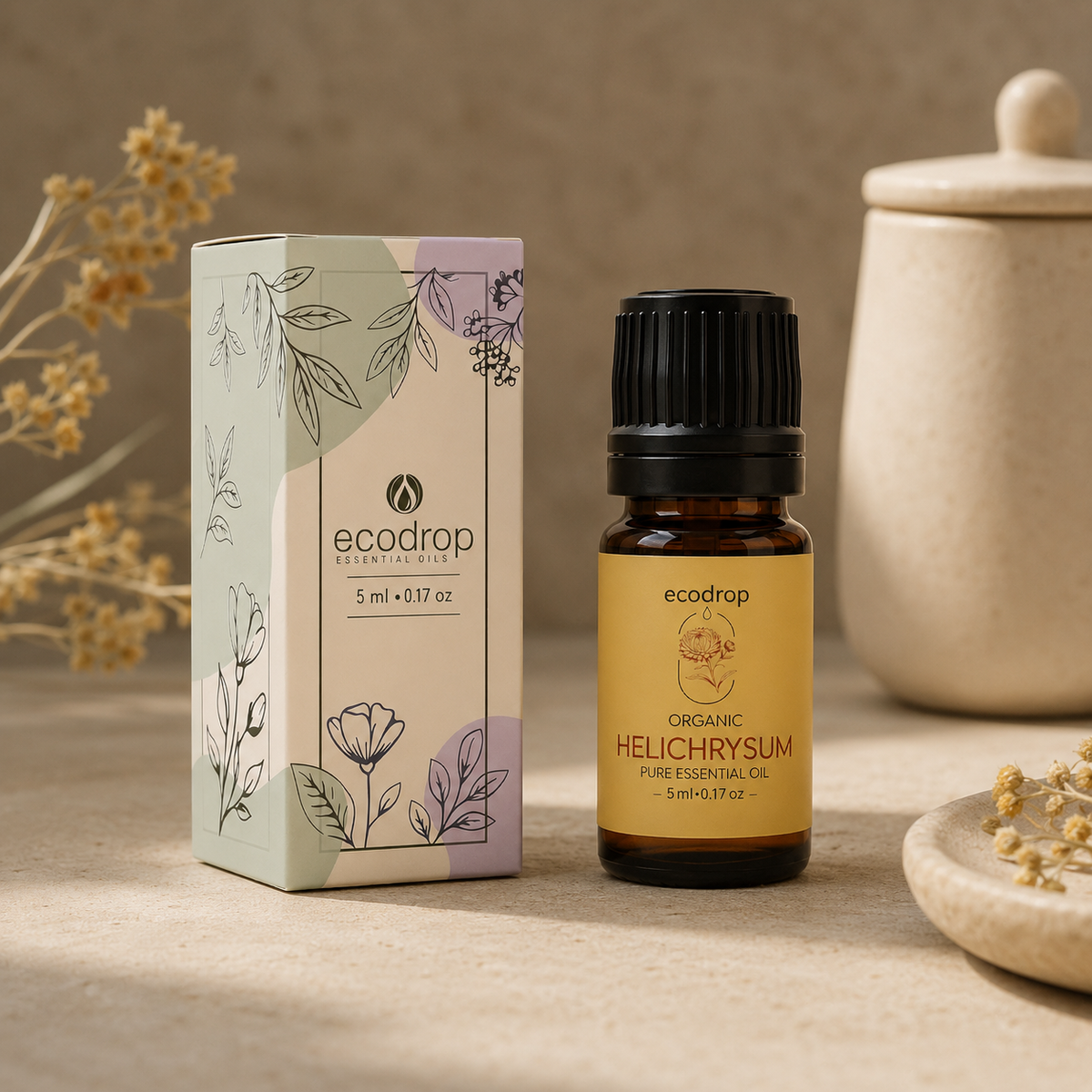 Helichrysum italicum essential oil 5ml bottle beside its Ecodrop gift box and dried immortelle flowers