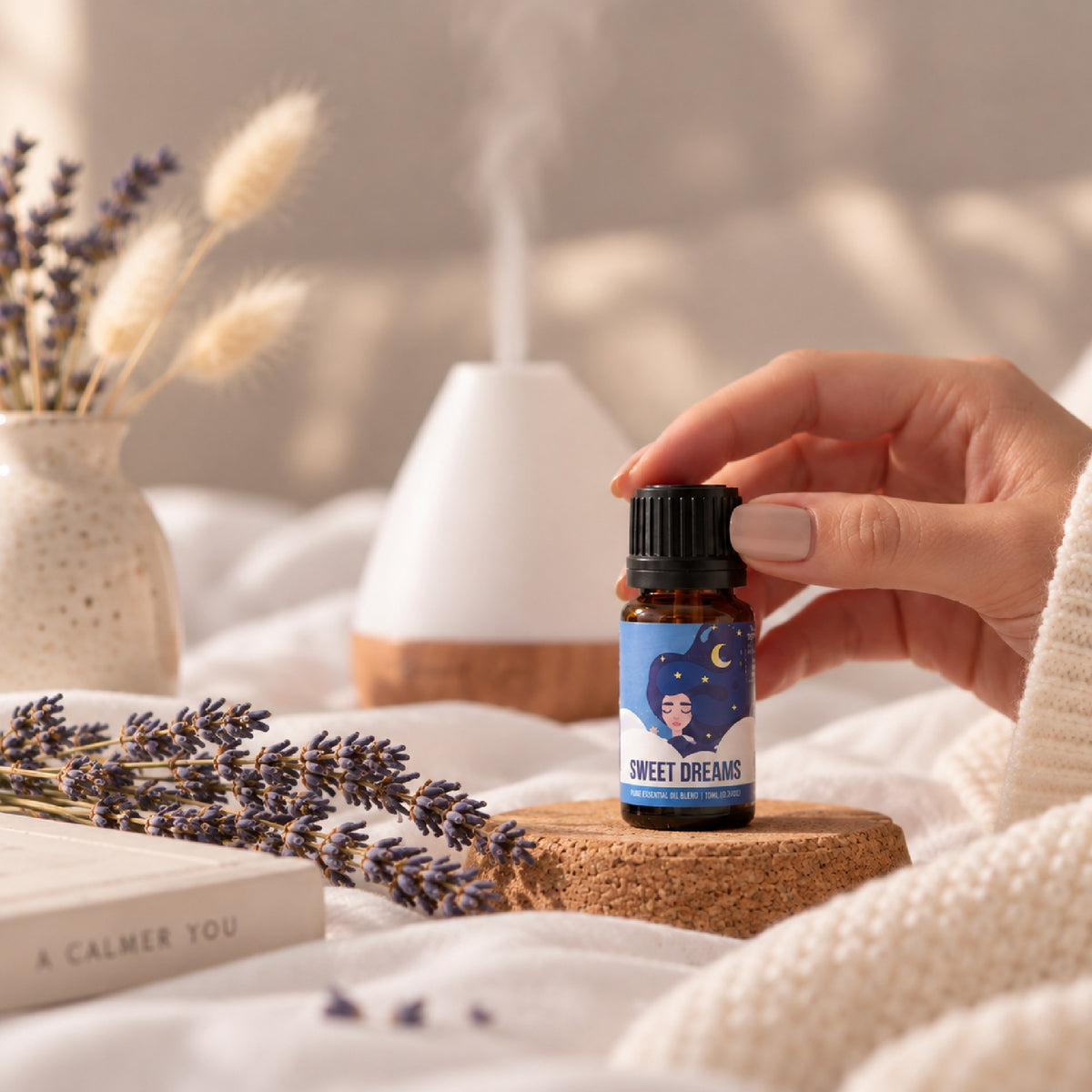 Sweet Dreams sleep blend held on a cork coaster by the bed with lavender