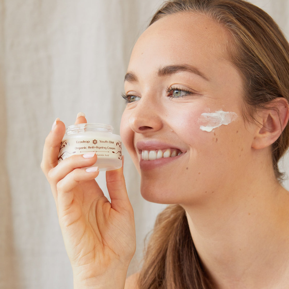 Woman holding Ecodrop Organic Anti-Ageing Cream for mature skin