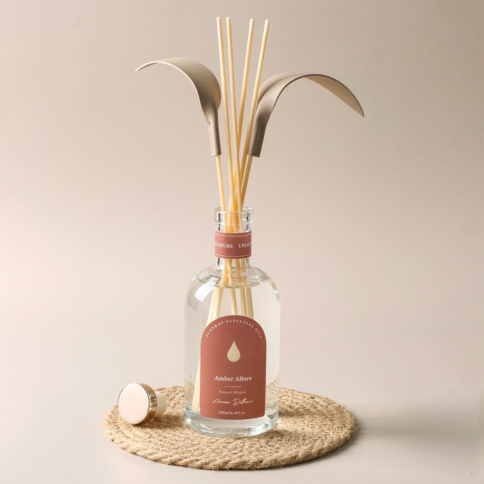 Amber Allure reed diffuser styled on a woven mat