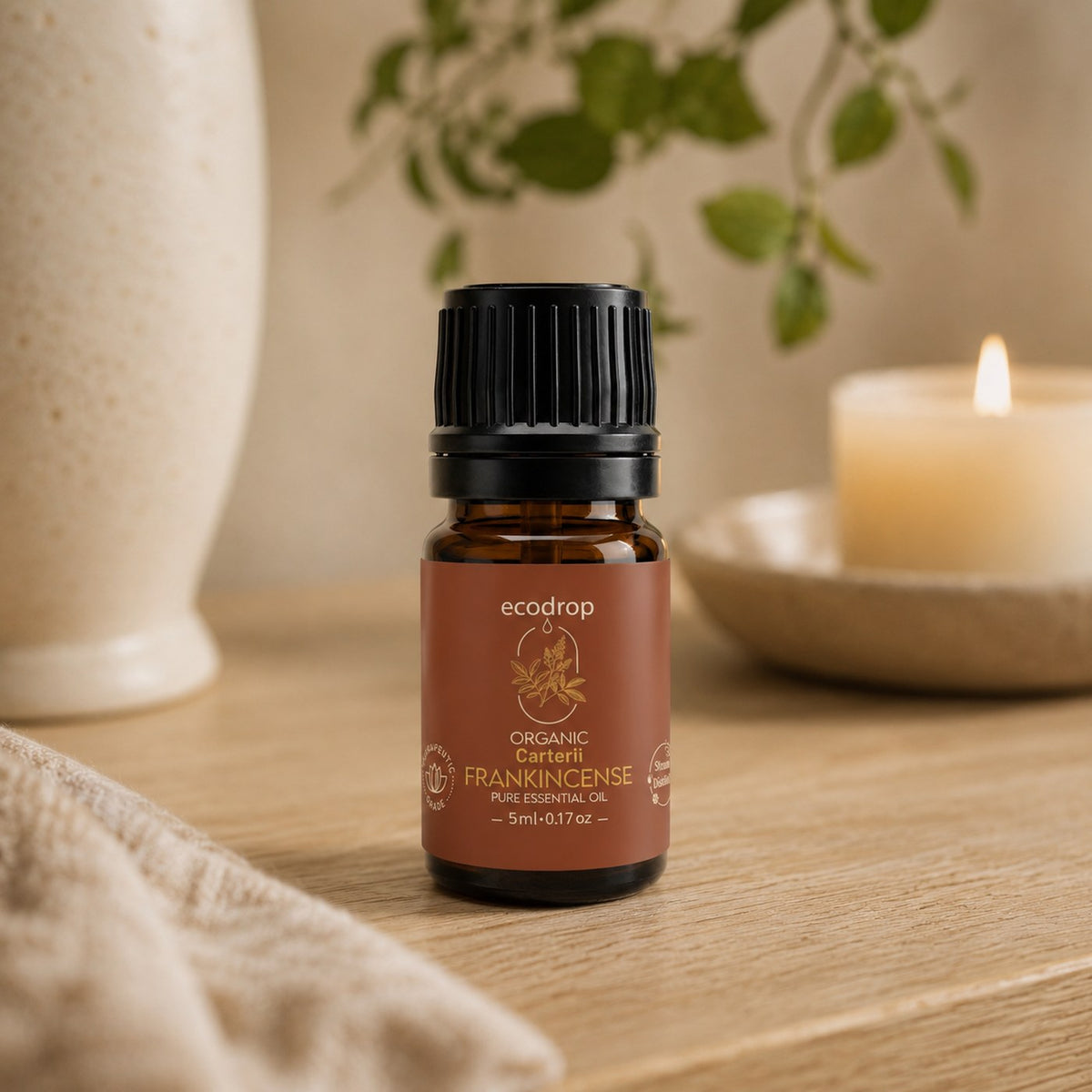 Frankincense Carterii essential oil on a wooden table with a lit candle