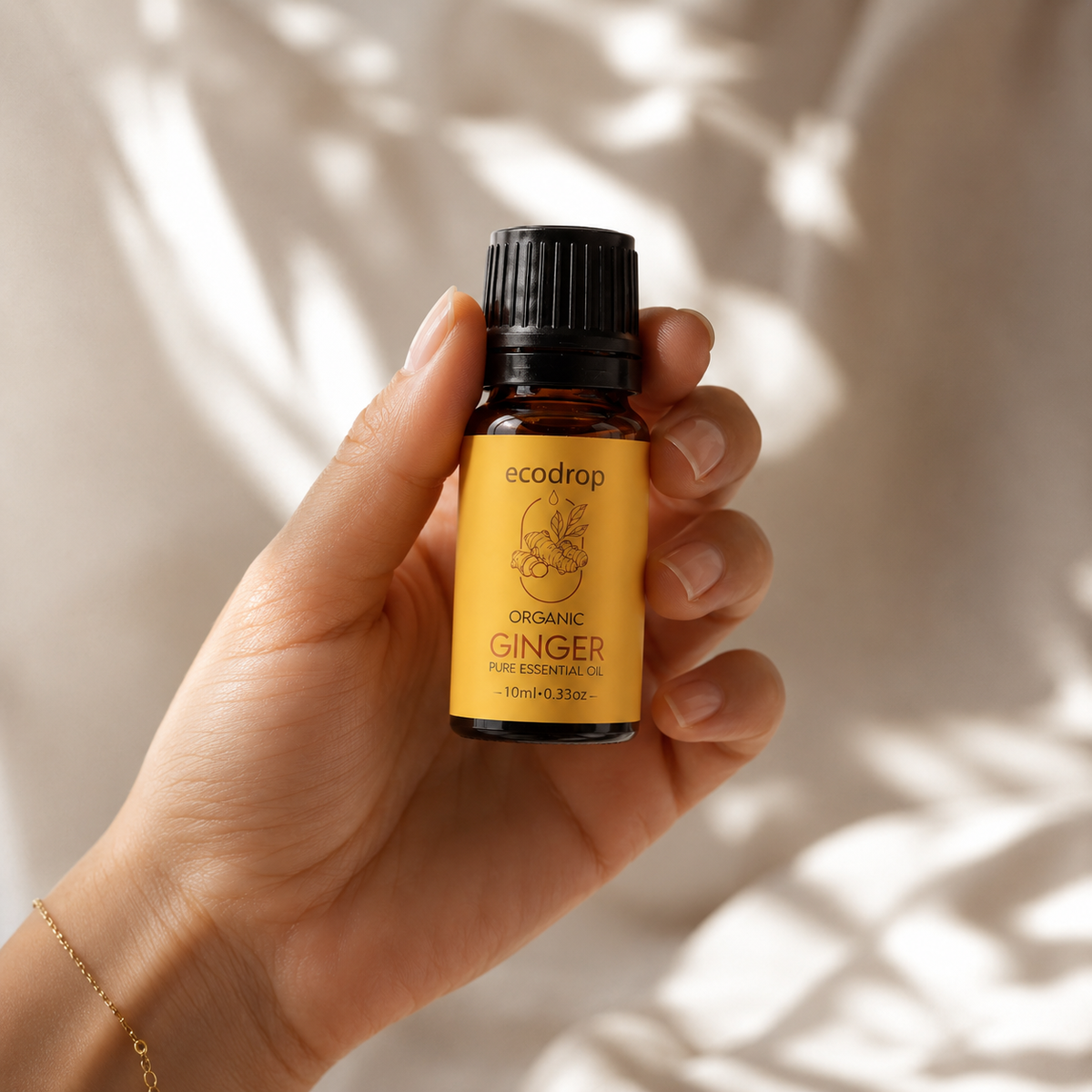 Hand holding a 10ml bottle of Ecodrop organic ginger essential oil
