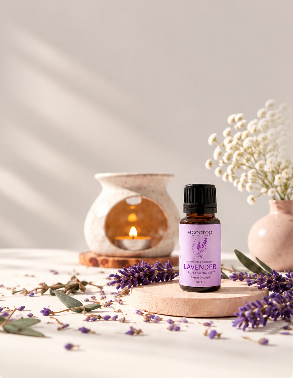 Lavender essential oil bottle with diffuser and flowers