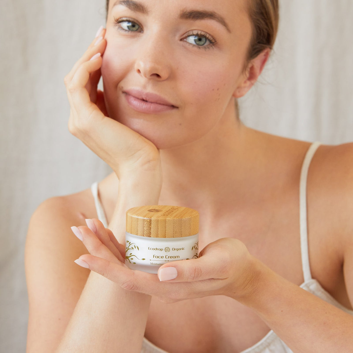 Woman holding a jar of Ecodrop Organic Face Cream, natural face cream for dry skin