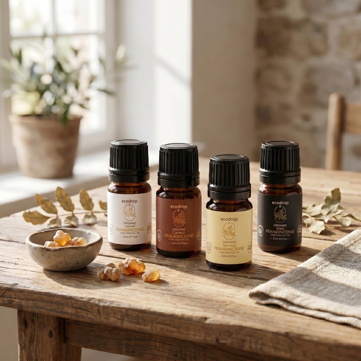 Sacred, Carterii, Serrata and Black frankincense oils on a wooden table with resin