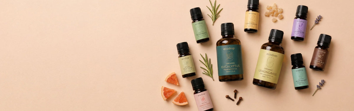 Organic essential oil bottles with citrus and spices on a warm beige background