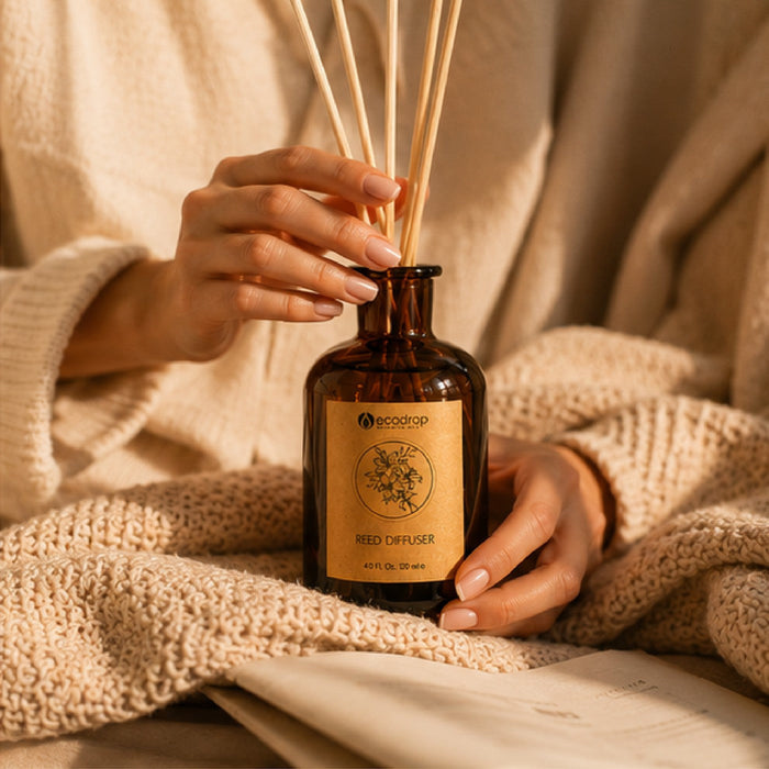 Hands holding the Rose Absolute reed diffuser wrapped in a cosy knit blanket