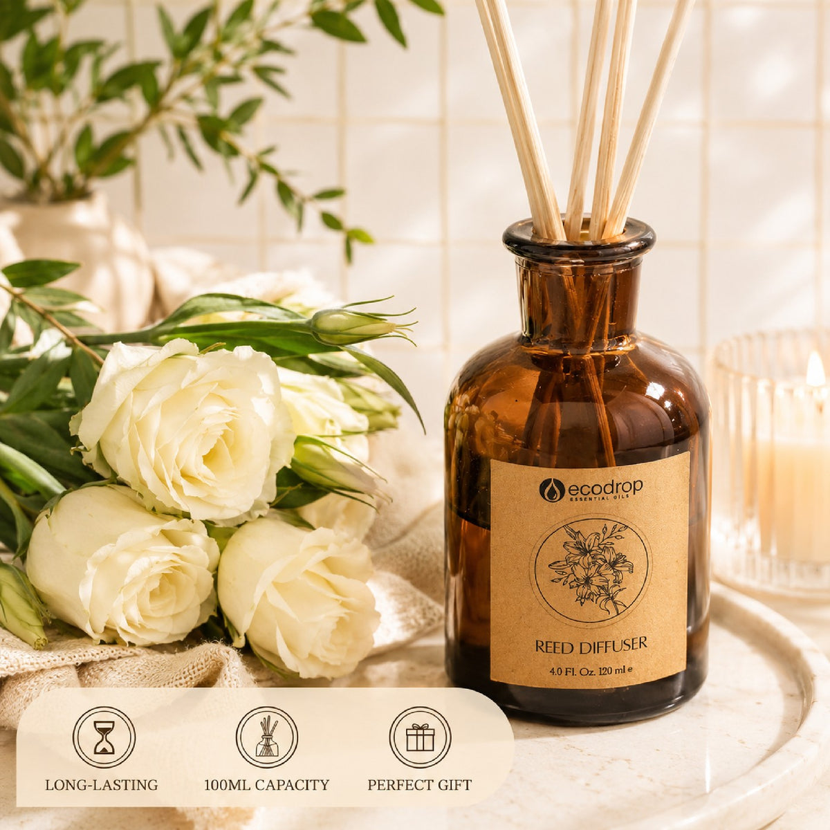 Rose Absolute reed diffuser on a tray with white roses, greenery and a candle