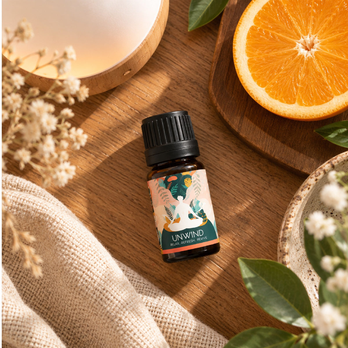 Unwind essential oil blend with sliced orange and a diffuser