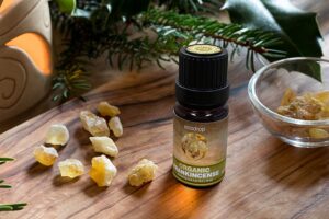 Organic Frankincense Essential oil on a table with frankincense resin 